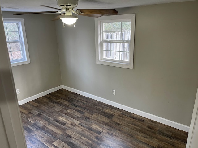 empty room with ceiling fan, plenty of natural light, and dark hardwood / wood-style flooring