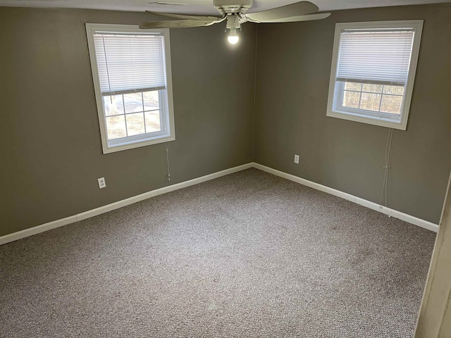 empty room featuring ceiling fan, carpet flooring, and a wealth of natural light