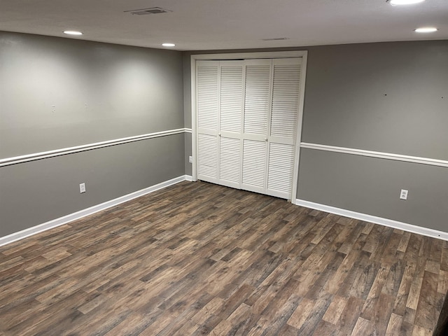 unfurnished bedroom with dark hardwood / wood-style floors and a closet