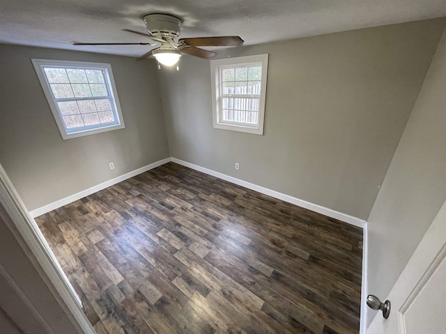 empty room with ceiling fan and dark hardwood / wood-style flooring