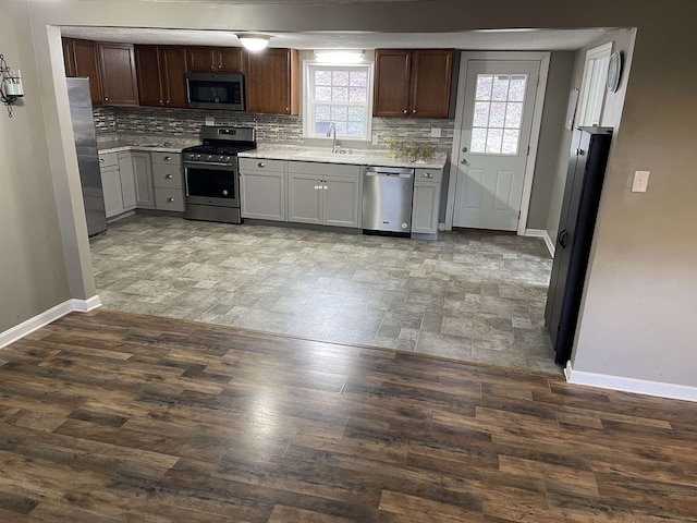 kitchen with backsplash, plenty of natural light, sink, and stainless steel appliances