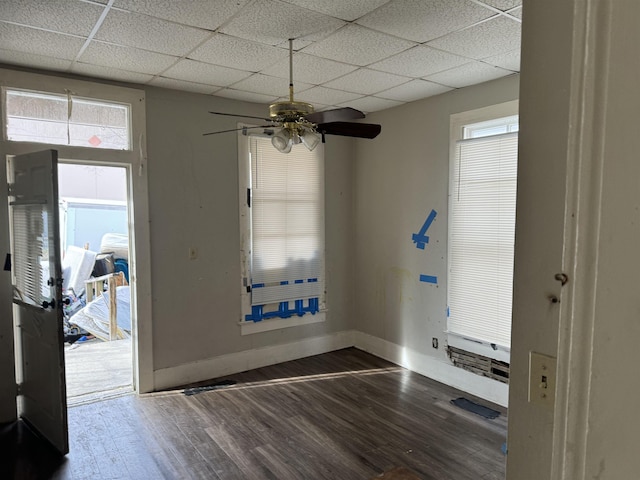 entryway with ceiling fan, a drop ceiling, and dark wood-type flooring