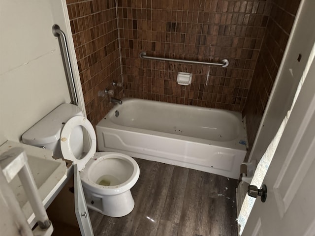 bathroom featuring toilet, tiled shower / bath combo, and wood-type flooring