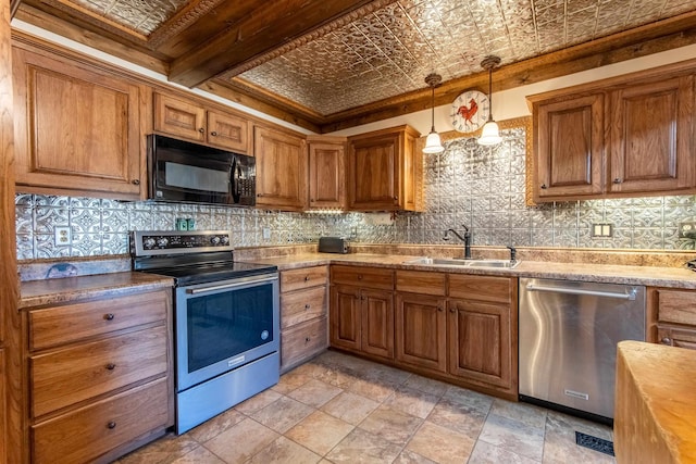 kitchen with decorative light fixtures, appliances with stainless steel finishes, sink, and tasteful backsplash