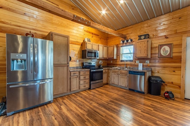 kitchen with wood walls, appliances with stainless steel finishes, dark hardwood / wood-style floors, lofted ceiling, and sink