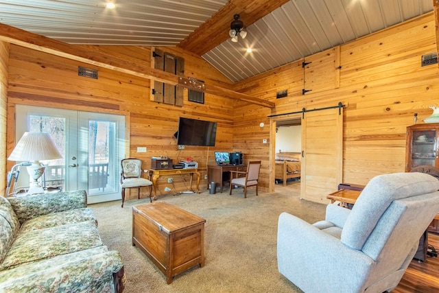 living room with carpet, a barn door, vaulted ceiling with beams, wooden walls, and french doors