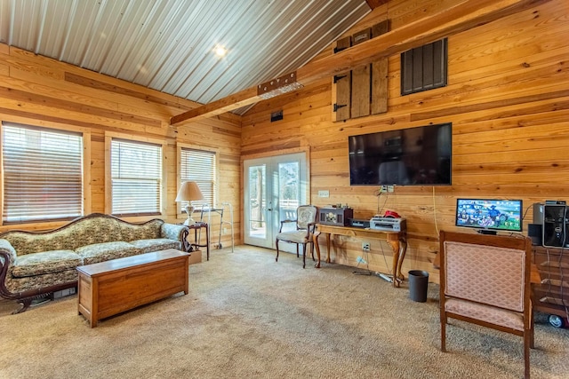 living room with high vaulted ceiling, light colored carpet, and wooden walls