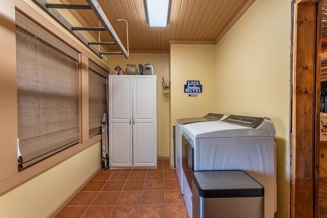 clothes washing area featuring independent washer and dryer, crown molding, dark tile patterned floors, wood ceiling, and cabinets