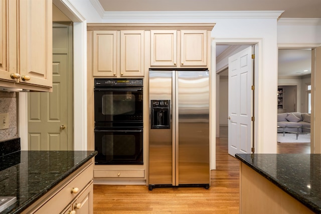 kitchen featuring black double oven, stainless steel fridge with ice dispenser, crown molding, and dark stone countertops