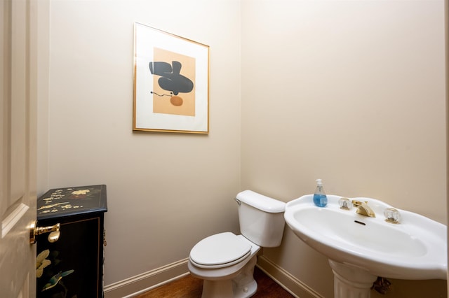 bathroom featuring sink, hardwood / wood-style floors, and toilet