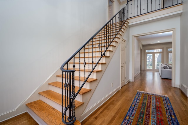 staircase featuring hardwood / wood-style flooring and french doors