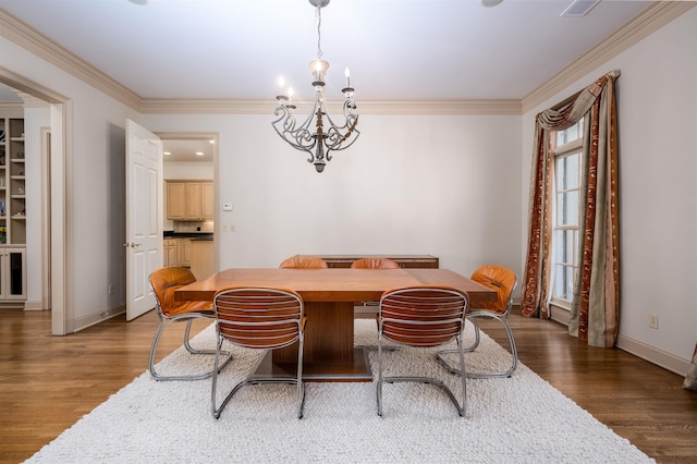 dining space featuring dark wood-type flooring, crown molding, and a notable chandelier