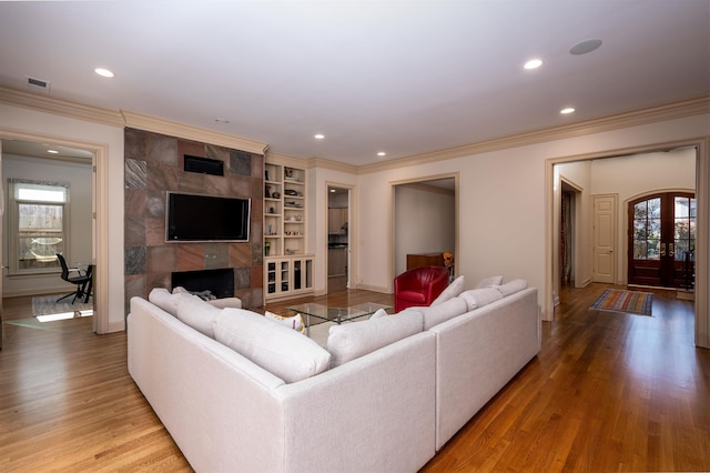 living room featuring hardwood / wood-style floors, built in features, and a wealth of natural light