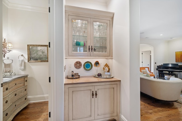 bar with ornamental molding and hardwood / wood-style flooring