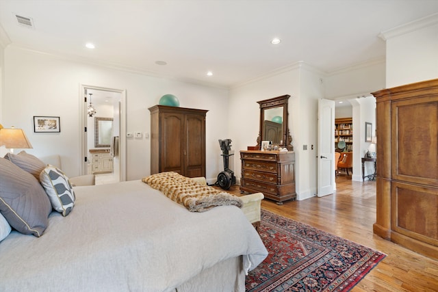 bedroom featuring ensuite bathroom, ornamental molding, and light wood-type flooring