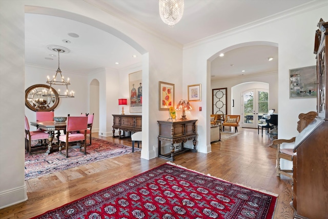 foyer with hardwood / wood-style floors, crown molding, and an inviting chandelier