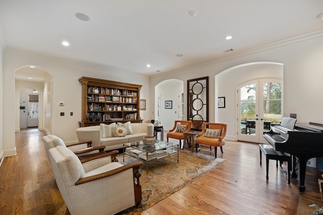 living room with light wood-type flooring, crown molding, and french doors