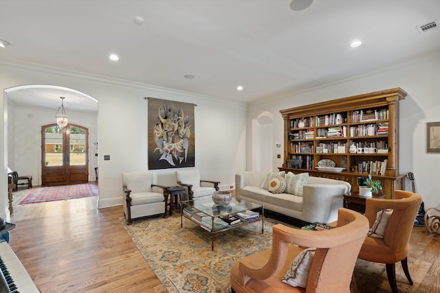 living room with french doors, ornamental molding, and wood-type flooring