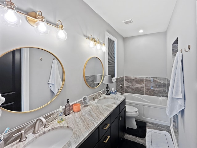 bathroom featuring a washtub, toilet, and vanity