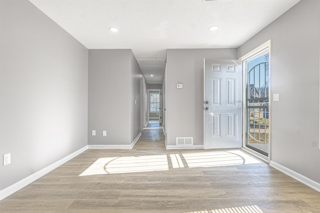 entryway featuring a textured ceiling and light hardwood / wood-style flooring