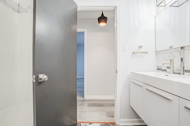 bathroom with tasteful backsplash, vanity, and wood-type flooring