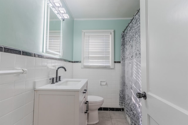 bathroom with toilet, tile walls, tile patterned floors, crown molding, and vanity