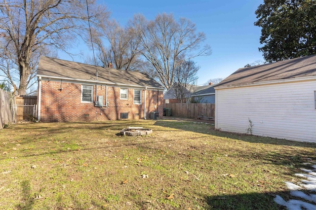 view of yard with central AC unit and a fire pit