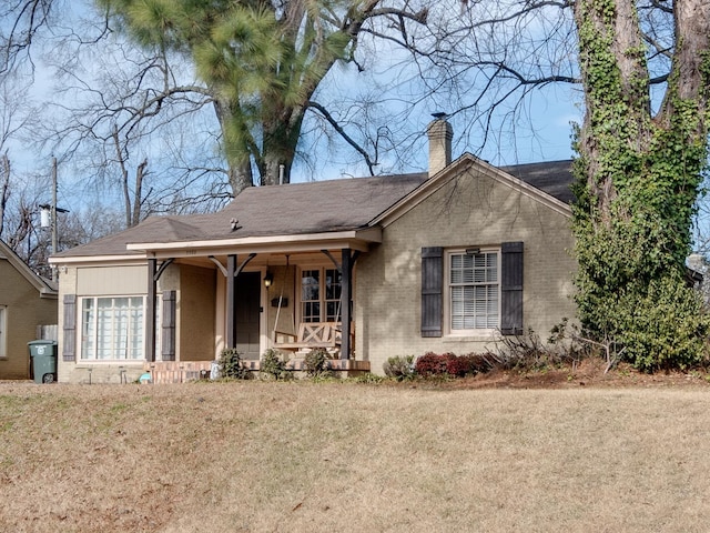 ranch-style home featuring a front yard and covered porch