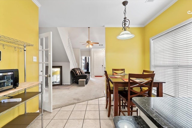 dining area with light carpet, ceiling fan, and ornamental molding