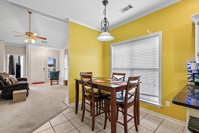 dining area with light carpet, ceiling fan, and crown molding