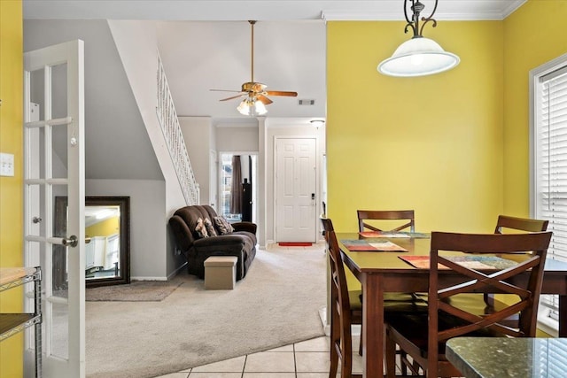 carpeted dining space featuring ceiling fan, a wealth of natural light, ornamental molding, and french doors