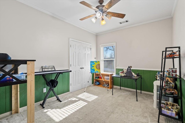 miscellaneous room with ceiling fan, carpet, wood walls, and crown molding