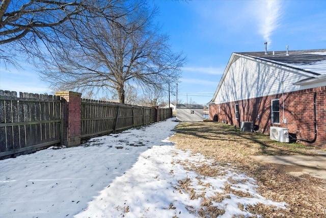 yard layered in snow featuring cooling unit and ac unit