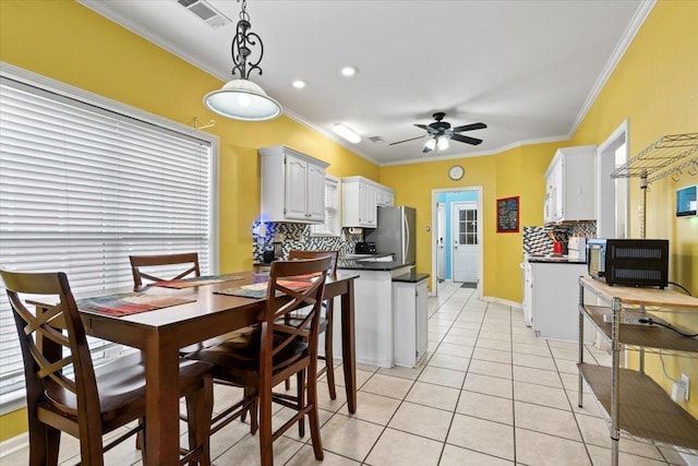 kitchen with pendant lighting, backsplash, white cabinetry, and crown molding