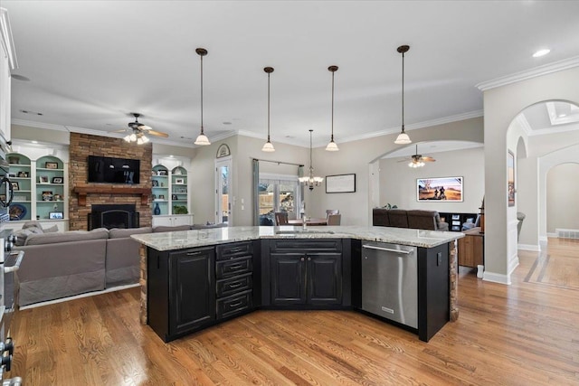 kitchen featuring ceiling fan with notable chandelier, dishwasher, hanging light fixtures, and an island with sink