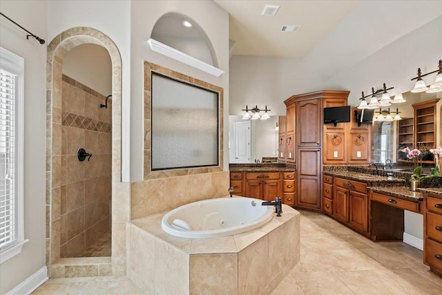 bathroom with vanity and shower with separate bathtub