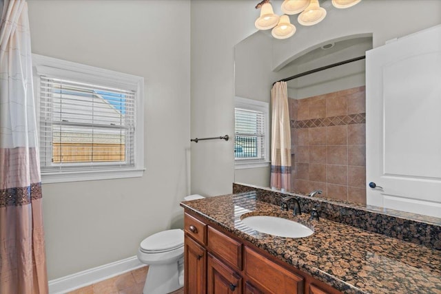 bathroom featuring toilet, a wealth of natural light, tile patterned floors, and vanity