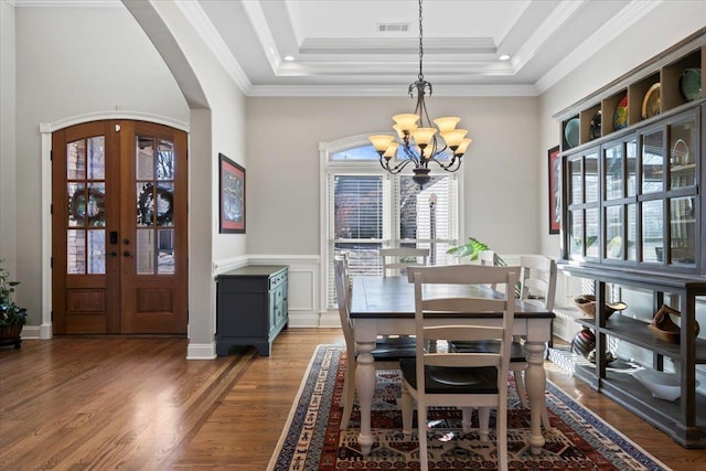 dining space featuring a chandelier, ornamental molding, french doors, and a tray ceiling