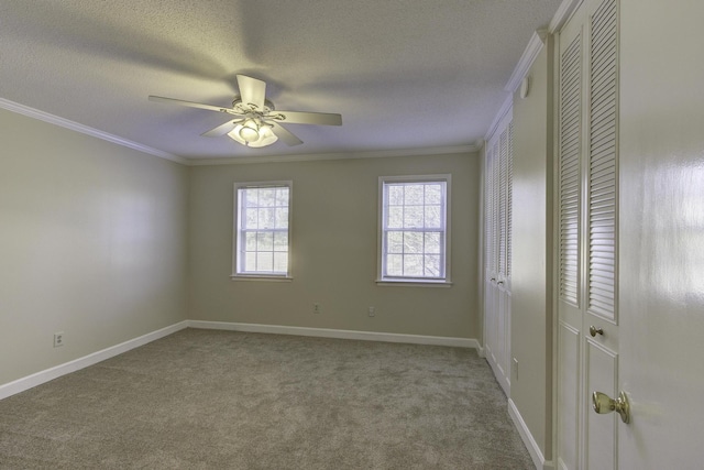 spare room with light carpet, ceiling fan, ornamental molding, and a textured ceiling