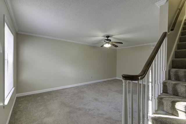 stairs featuring carpet, ceiling fan, ornamental molding, and a textured ceiling