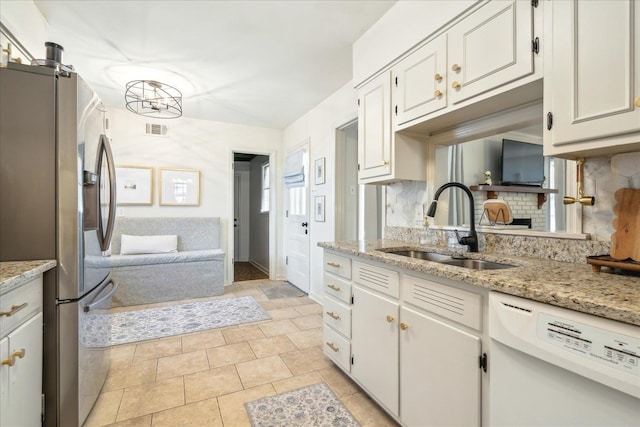 kitchen with white cabinetry, stainless steel refrigerator with ice dispenser, tasteful backsplash, white dishwasher, and sink