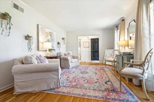 living room with light wood-type flooring and ornamental molding