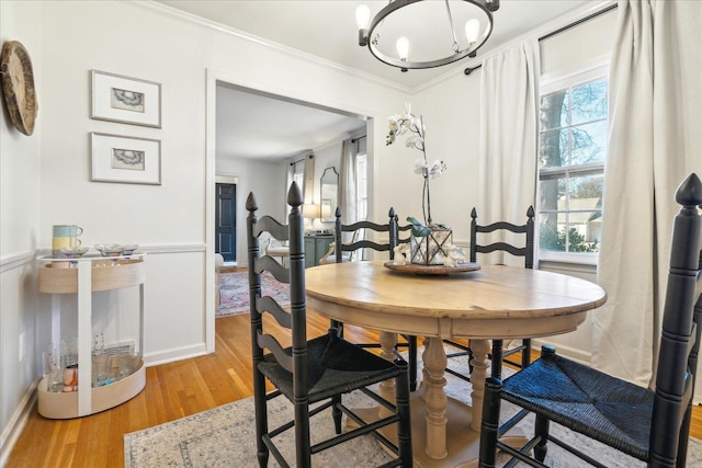 dining room featuring an inviting chandelier, ornamental molding, and hardwood / wood-style floors