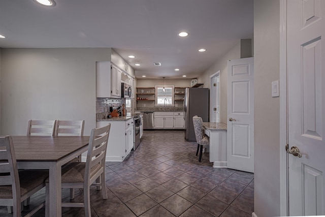 kitchen featuring light stone counters, white cabinetry, and stainless steel appliances