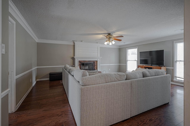 living room with a brick fireplace, ornamental molding, a wealth of natural light, and ceiling fan