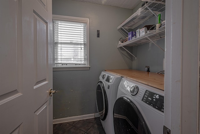 laundry area featuring washing machine and dryer, a textured ceiling, and dark tile patterned floors