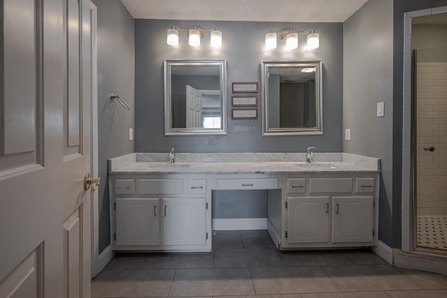 bathroom featuring vanity, a textured ceiling, tile patterned floors, and an enclosed shower