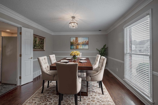 dining space with a textured ceiling, dark hardwood / wood-style floors, and a healthy amount of sunlight