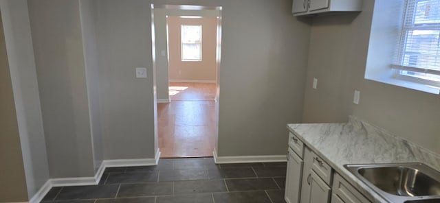 kitchen featuring white cabinets and dark tile patterned flooring