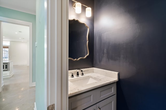 bathroom with ornamental molding, vanity, and concrete floors